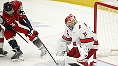 Branká Caroliny Frederik Andersen zasahuje proti Johnu Carlsonovi z...