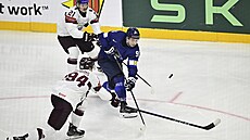 Finský úto�ník Juho Lammikko se sna�í dostat puk p�es Loty�e Kristianse Rubinse...