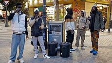 Imigranti se shromaují, aby obdreli jídlo bhem rozdávání potravin...