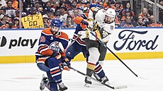 Útoník Vegas Tomá Hertl (vpravo) posílá puk na branku Edmontonu kolem Adama...