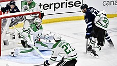 Branká Dallasu Jake Oettinger zasahuje proti anci Adama Lowryho z Winnipegu.