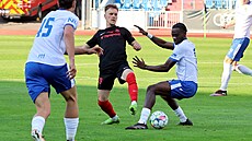 Záloník Slezského FC Jakub Rezek se snaí vypíchnout balon ostravskému Roanu...