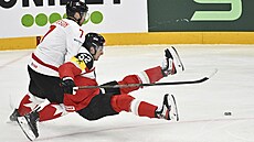 Mike Matheson z Kanady a Rakuan Paul Huber v souboji o puk.