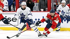 Tomá Nosek (92) z Florida Panthers se snaí zabrzdit Simona Benoita (2) z...