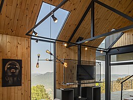 Prosklený je celý vstupní �tít, svislý pás uprost�ed chaty od st�echy a� po...