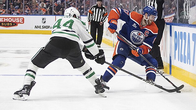 Connor McDavid (vpravo) z Edmonton Oilers krot u mantinelu puk, tla na nj Cody Ceci z Dallas Stars.