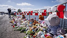 Lidé nosí v nizozemském  ve Winschotenu kvtiny a hraky k místu, kde policie...