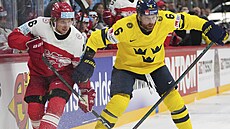 védský obránce Adam Larsson v souboji s Jonasem Rondbjergem z Dánska