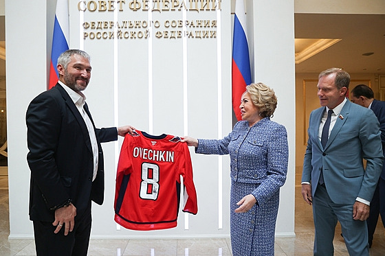 Hokejový útoník Alexandr Ovekin pedává svj podepsaný dres ruské pedsedkyni...