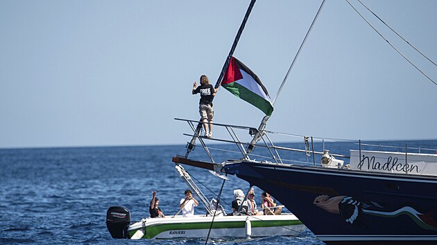 Klimatick aktivistka Greta Thunbergov stoj u palestinsk vlajky po nalodn na lo Madleen v Itlii. (1. ervna 2025)