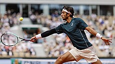 Ital Lorenzo Musetti se natahuje po balonku bhem tvrtfinále Roland Garros.