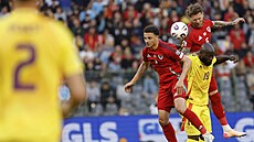 Ethan Ampadu (nahoe) a Joe Rodon z Walesu v hlavikovém souboji s Romelem...