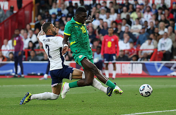 Ismaila Sarr ze Senegalu dává gól v utkání proti Anglii.Marn ho stíhá Kyle...