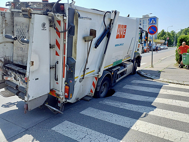 Pod popelářským autem se v Praze propadla silnice, z díry ho vyprostí jeřáb
