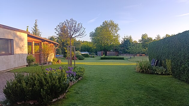 Rann pohled na zahradu s trvalkovmi zhony, pergolou i zeleninovmi zhony, kompostry a loukou