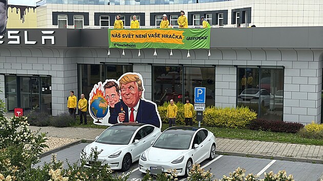 Aktivist z hnut Greenpeace vylezli rno na stechu prodejny Tesla v estlicch u Prahy. (11. ervna 2025)
