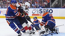 Brad Marchand z Floridy tísnný Coreyem Perrym pekonává Calvina Pickarda v...