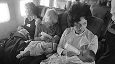Manelky pilot krmí vietnamské dti pi peletu ze Seattlu do Chicaga.