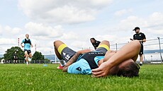 Vyerpaný teplický fotbalista Matyá Kozák leí na trávníku.