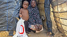 Uprchlíci z Burkina Fasa s balíkem pomoci od turecké humanitární organizace...