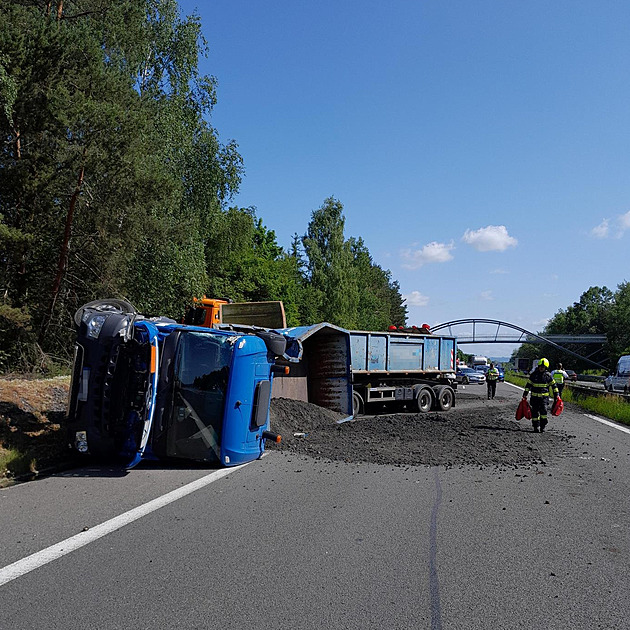 Na D10 se převrátil náklaďák, vysypaný materiál hasiči odklízeli v respirátorech