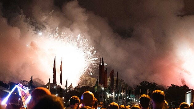 Festival Glastonbury otevřel brány už ve středu brzy ráno, hlavní program začal v pátek. Lidé sledují ohňostroj nad Stone Cirle v kopcích nad farmou