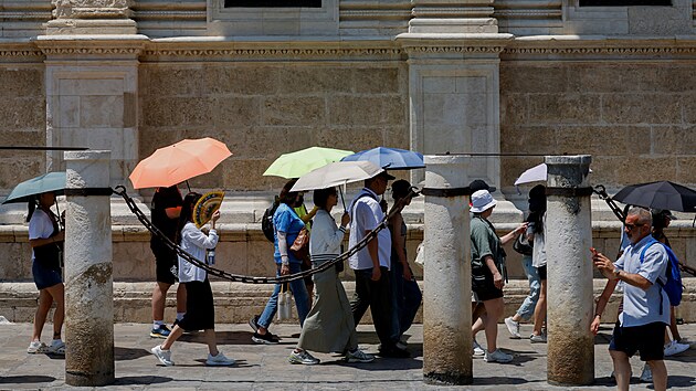 Turist se chrn detnky ped sluncem ve panlsk Seville. (29. ervna 2025)