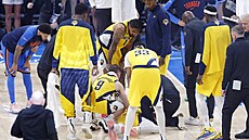 Zranný Tyrese Haliburton z Indiana Pacers je obklopen spoluhrái v sedmém...