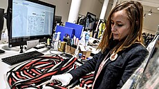 Pracovnice kontroluje produkty v logistickém centru online tr�i�t� Vestiaire...