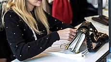 Pracovnice kontroluje produkty v logistickém centru online tr�i�t� Vestiaire...