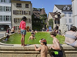 Mladí lidé se koupou ve fontán� b�hem vlny veder v centru �výcarské Basileje....