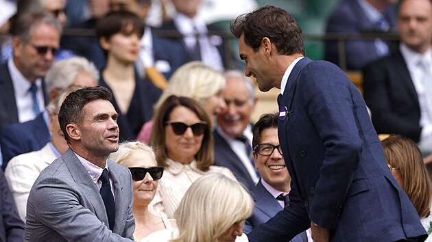 Roger Federer se zdrav s bvalm hrem kriketu Jamesem Andersonem ve Wimbledonu.