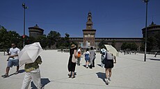 Turisté ped hradem Sforzesco v Milán kryjící se detníky bhem vlny veder v...