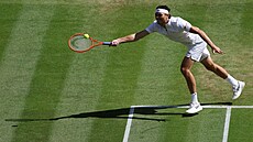 Taylor Fritz se natahuje po míku ve tvrtfinále Wimbledonu.
