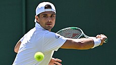 Amerian Marcos Giron se napahuje k úderu ve druhém kole Wimbledonu.