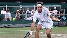 Jakub Meník spchá za balonkem ve druhém kole Wimbledonu.