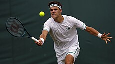 Jakub Meník se soustedí na úder ve tetím kole Wimbledonu.