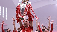 Liverpoolský fotbalista Diogo Jota oslavuje s trofejí pro vít�ze Premier League...