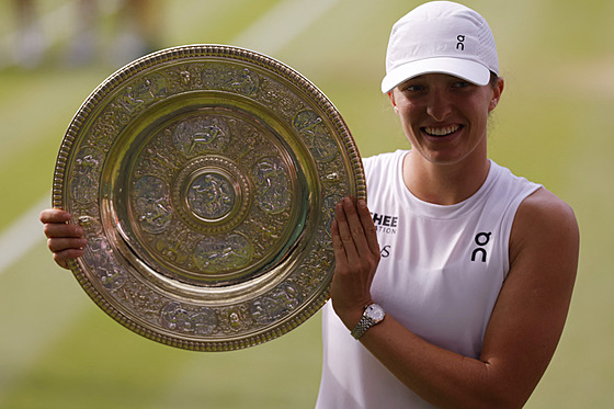 Iga wiateková pózuje s trofejí pro vítzku Wimbledonu.