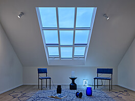 Sedlovou stechu krytou betonovými takami otevírají velkorysá ateliérová okna.