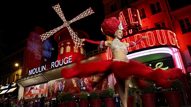 Tanenice francouzskho kanknu tan ped kabaretem Moulin Rouge bhem oslav obnoven provozu jeho ikonickho vtrnho mlna. (10. ervence 2025)