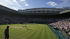 Zaplnný Centrální dvorec ve Wimbledonu sleduje semifinále mezi Igou...