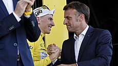 Tadej Pogaar pijímá gratulaci od francouzského prezidenta Emmanuela Macrona...