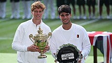 Vítzný Jannik Sinner (vlevo) a poraený Carlos Alcaraz pózují s trofejemi po...