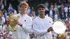 Vítzný Jannik Sinner (vlevo) a poraený Carlos Alcaraz pózují s trofejemi po...