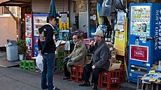 Japon�tí senio�i odpo�ívají p�ed místním obch�dkem a vedou spole�enskou...