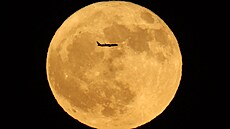 Úpln�k p�ezdívaný Jelení m�síc protíná letadlo na nebi v kalifornském Adelantu....