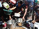 Palestinci, kteí trpí hladem, se shromaují u výdeje jídla z charitativní...