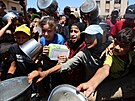 Palestinci, kteí trpí hladem, se shromaují u výdeje jídla z charitativní...