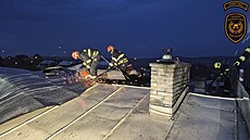 Hasi�i kv�li bou�kám �e�ili po�kozené st�echy. (21. �ervence 2025)